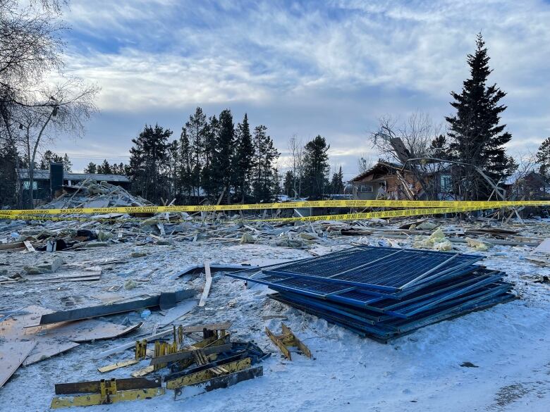 Construction debris is seen on a snowy residential lot.