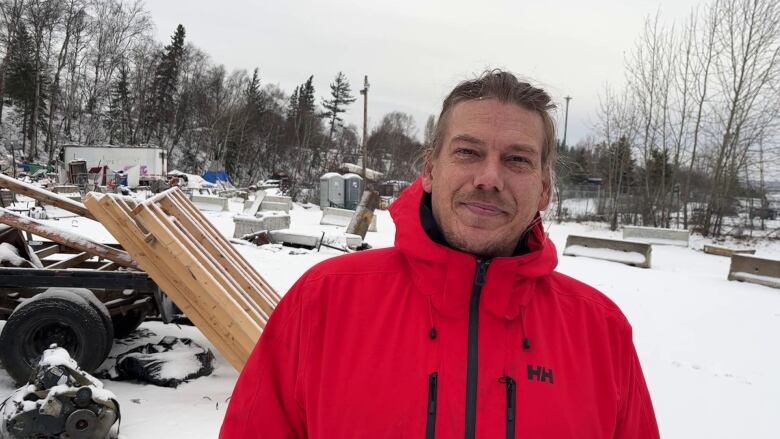 Man stands in snowy backdrop with red jacket