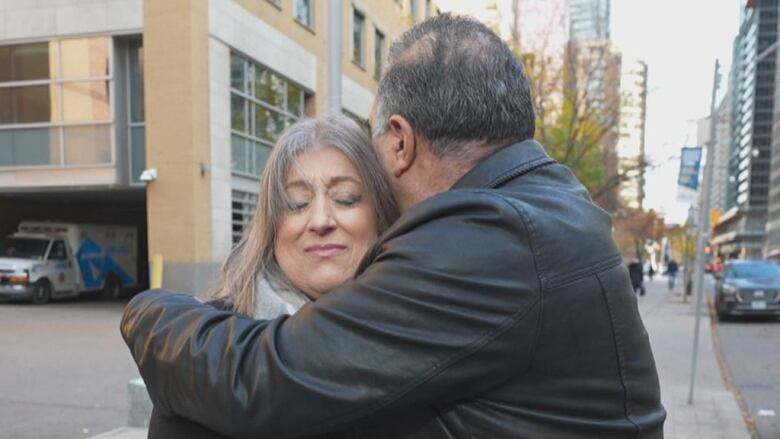 A woman hugging a man on a Toronto street.