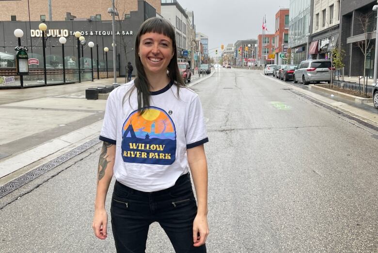 Woman poses for photo in the middle of the street in a downtown core