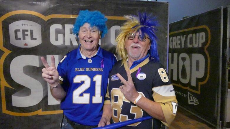 Two men in sports jerseys and blue and gold wigs.