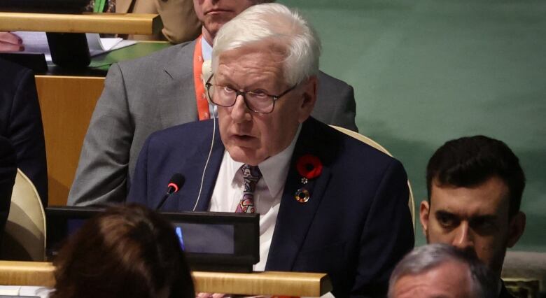 A man talks behind a desk