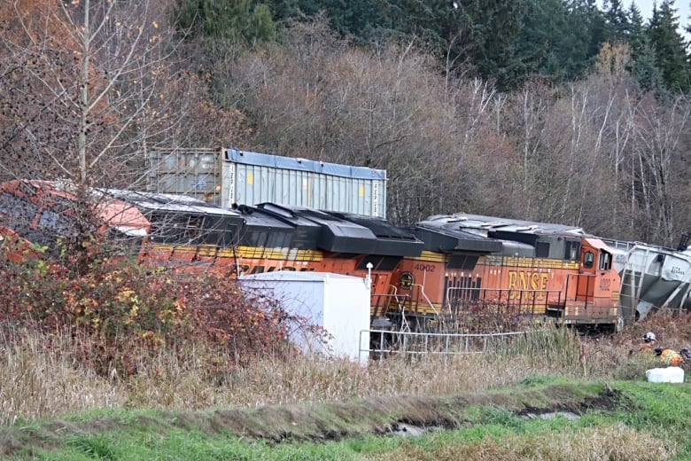 A derailed train leans on track infrastructure.