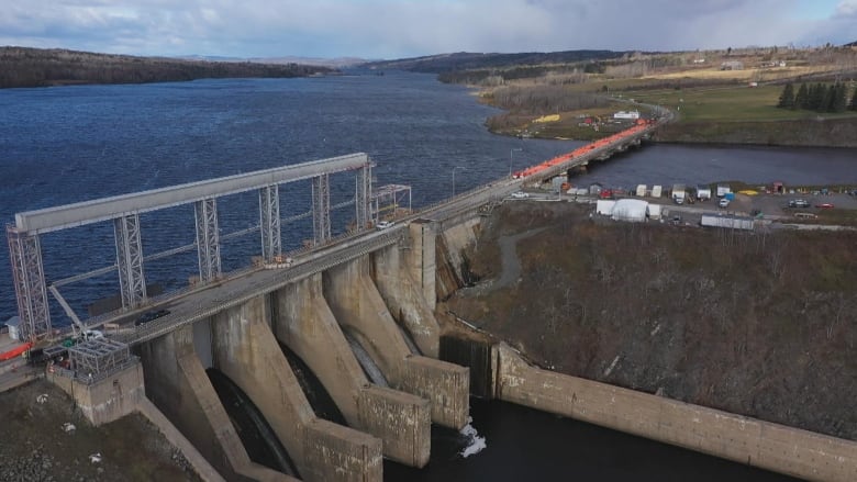 A dam and a bridge. The bridge has a layer of orange covering it.