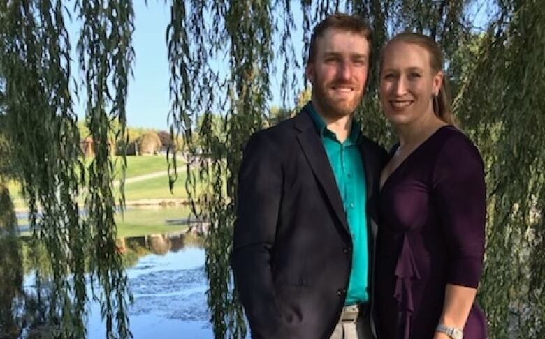 couple in front of lake and trees