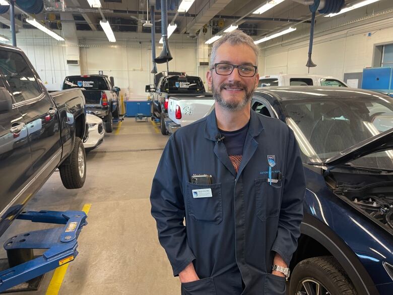 A man stands beside a car.