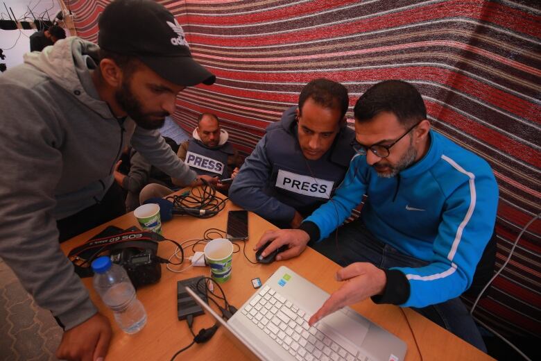 Palestinian journalists from Gaza gather in Hamad at a school which is being used to house people forced from their homes.