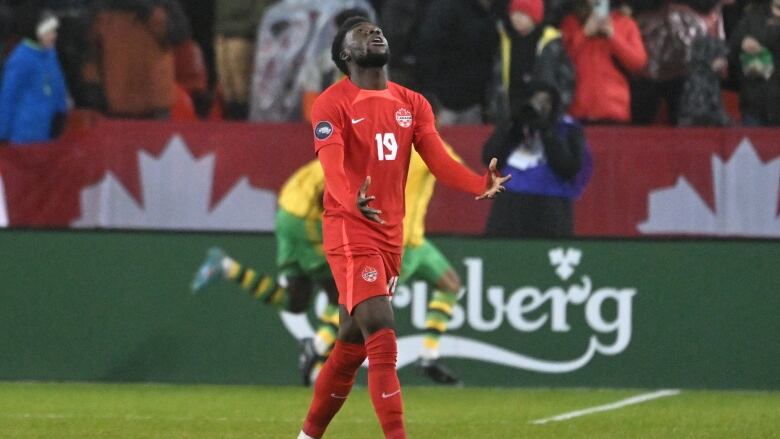 A soccer player looks to the sky.