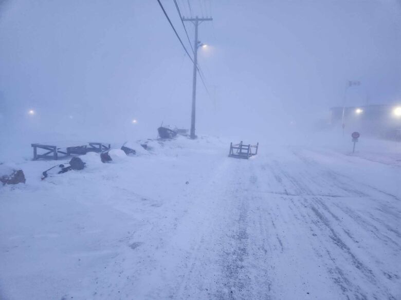 A snowy street with wind blowing snow across the image. 