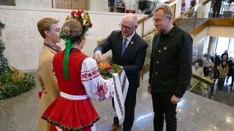 Four people gather in a rotunda to enjoy a cultural dish.