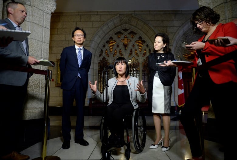 Sen. Chantal Petitclerc, centre, speaks to reporters during a press conference as Sen. Yuen Pau Woo, left, and Sen. Raymonde Saint-Germain, the Independent Senators Group (ISG) facilitator, look on.