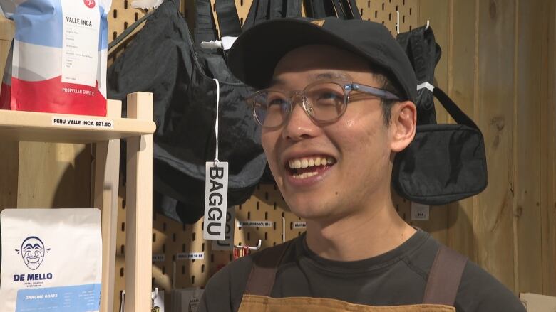 A man smiles while speaking in a coffeehouse.