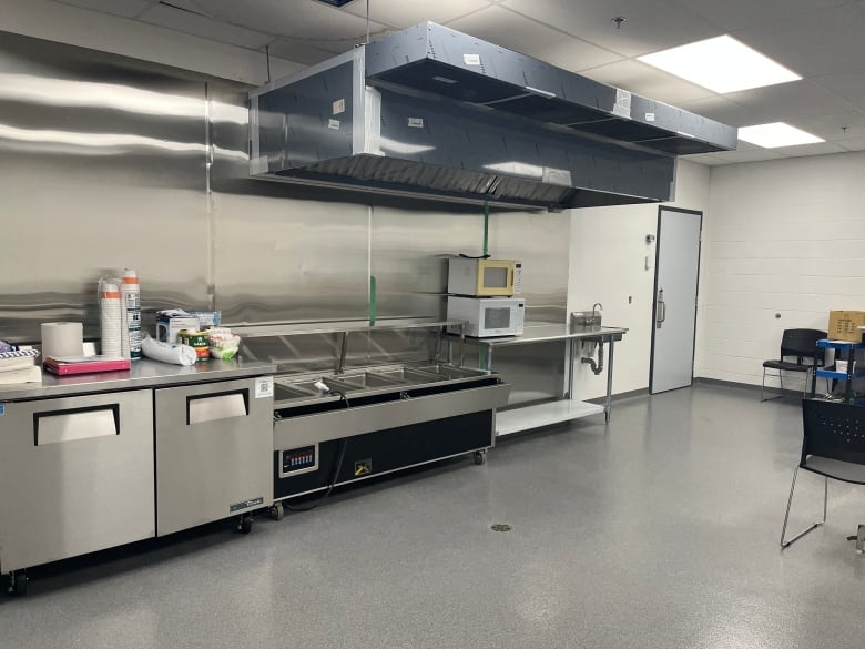 Kitchen equipment sits unused, including stainless steel fryers. 