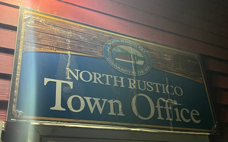 A sign welcomes people into North Rustico's town hall, taken at night.