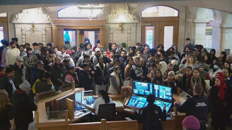 On November 20, guests at the legislature wait at the front desk to be allowed in. Following a protest Monday afternoon inside the chamber, the legislative security force has changed the rules for guests coming to the public gallery.