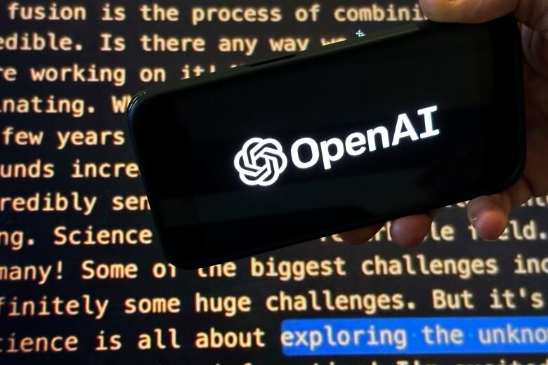 The OpenAI logo is seen on the screen of a mobile phone in New York.