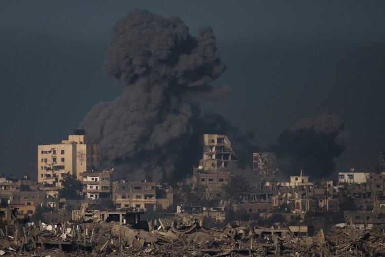 A large cloud of black smoke is shown above buildings in a wide view.