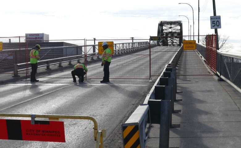 Work crews put up barricades to block access to a bridge