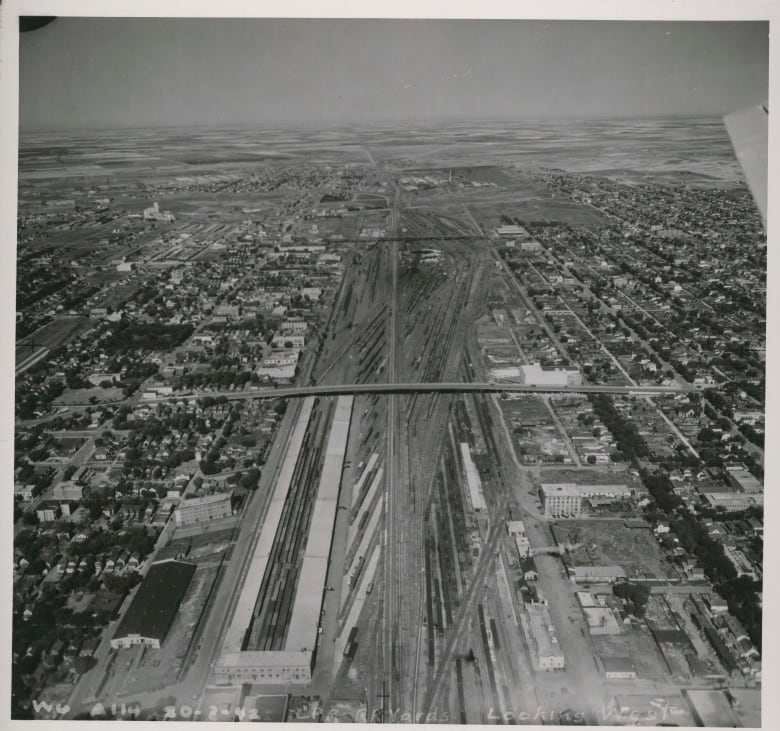 Black and white aerial photo of train yards and bridge