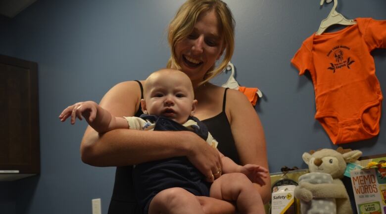 A woman holds a baby 