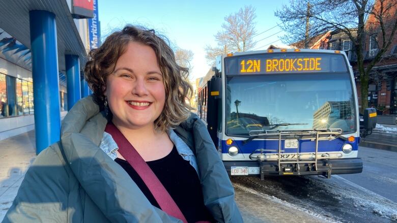 Cassandra LeBlanc stands in front of a bus in downtown Fredericton.