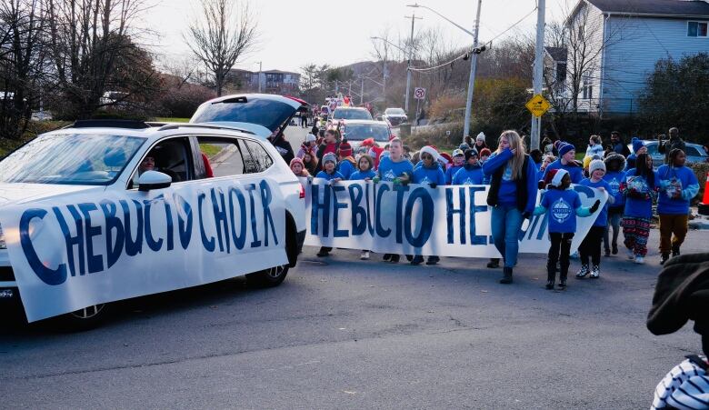 people in blue t-shirts holding a banner that says 