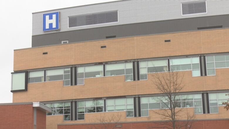 A building with a hospital symbol on the top. 