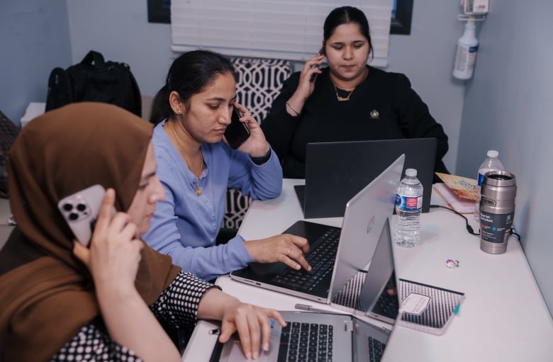 Women on phones and laptops.