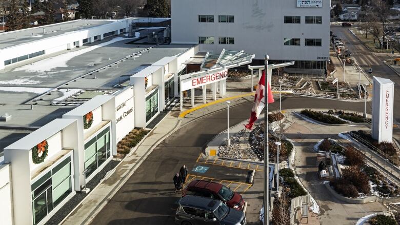 The outside of a hospital is shown from above. A sign saying 