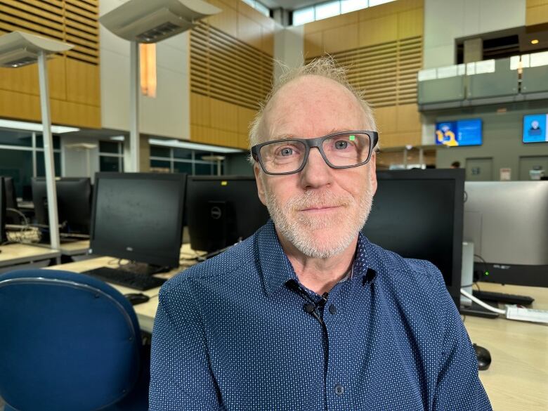 A man sits in a computer room.