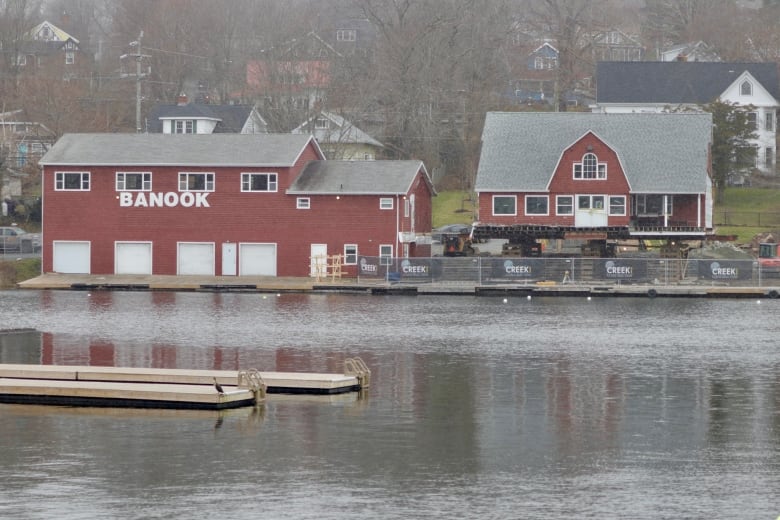 A red house-like building next to a lake.