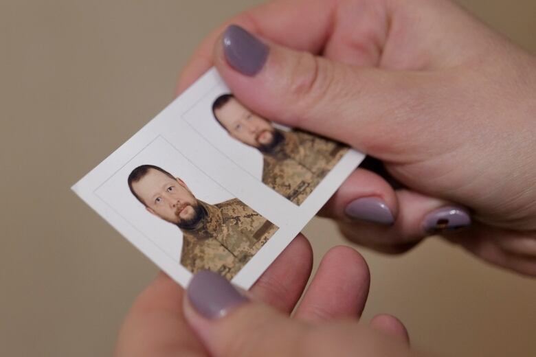 Kyiv resident Antonina Danylevych holds up a photo of her husband, who is serving in the fight against Russia's invasion of Ukraine.