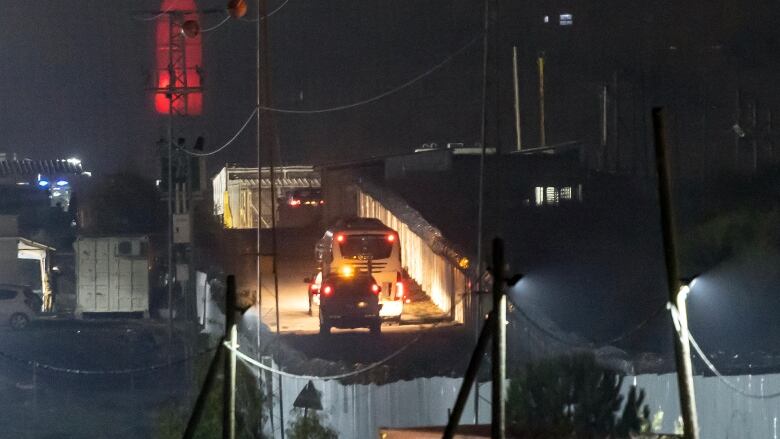 A Red Cross bus carrying newly released Palestinian prisoners drives outside the Israeli Ofer military prison.