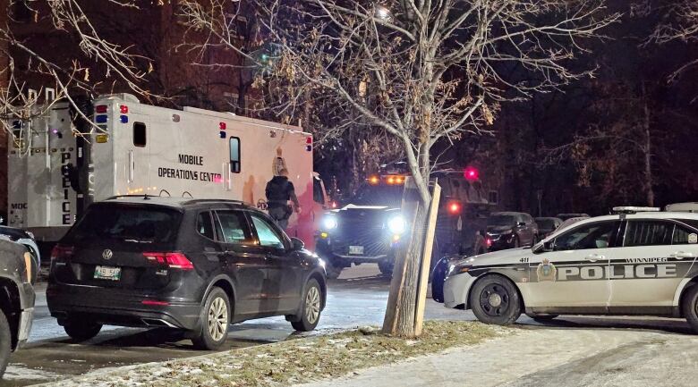 Multiple police vehicles on a snowy street. 