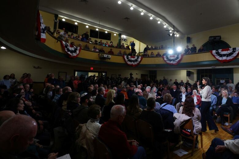 Haley speaking to audience seated across two floors in a town hall meeting