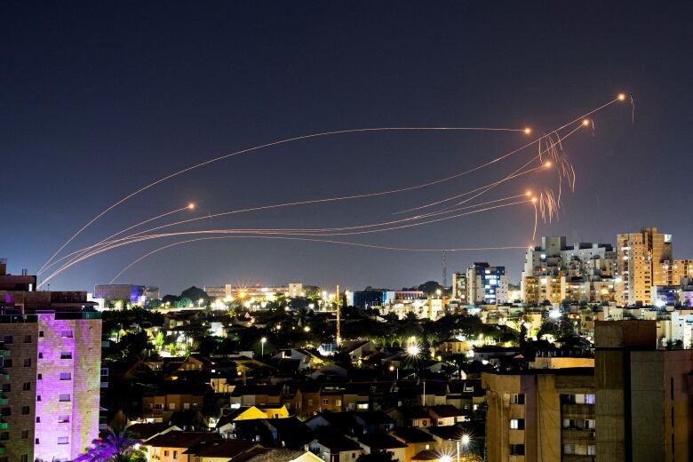 Rockets explode in the sky as Israel intercepts them with an anti-missile system.