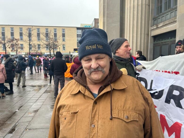 A man stands outside in the rain.