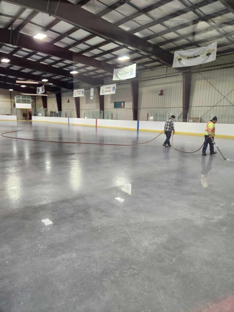 Who men hose down a rink with a very thin layer of ice on it.