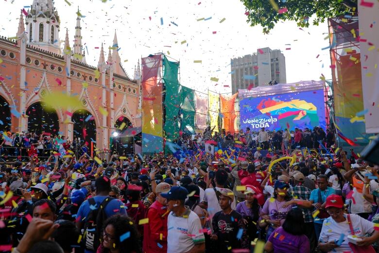 A large crowd cheers as colourful streamers and confetti fall from the sky.