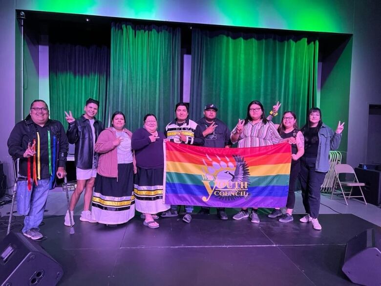 A group of two-spirit and LGBT members and ally's posing for a photo from a conference. 