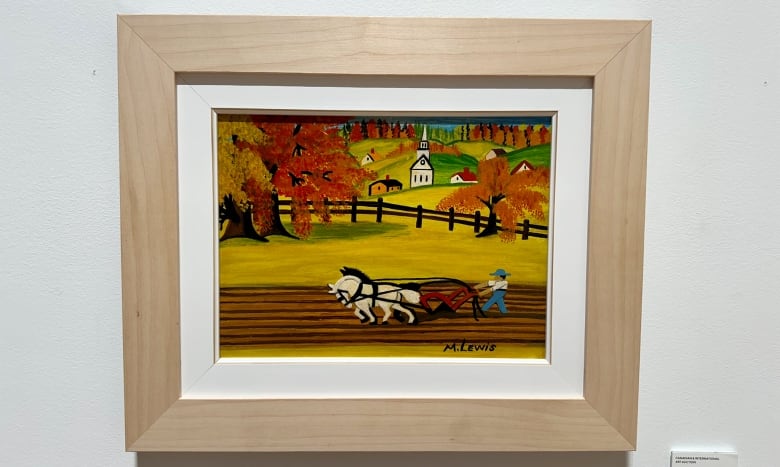 A framed painting of a pair of horses plowing a field. 