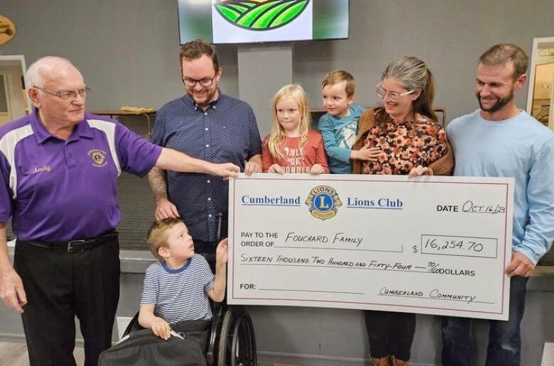 The Fouchard-Mykytyn family receive a cheque during a fundraising event.