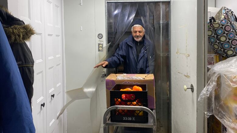 A volunteer pushes a cart out of the walk-in fridge at the West Island Assistance Fund food bank in Montreal. 