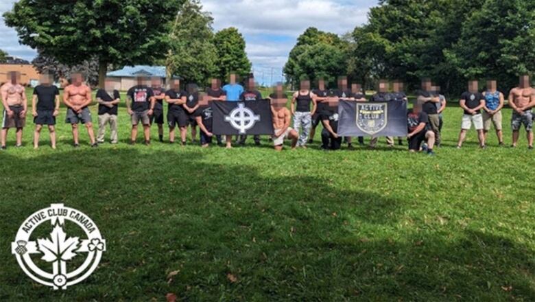 A group of men standing with flags in a park on a sunny day.