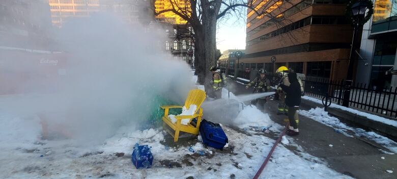 Firefighters extinguish a burning tent.