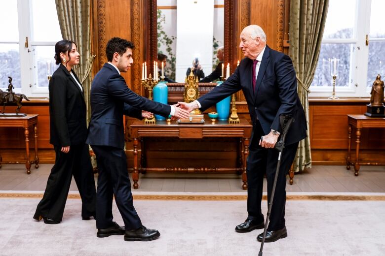 Two people shake hands.