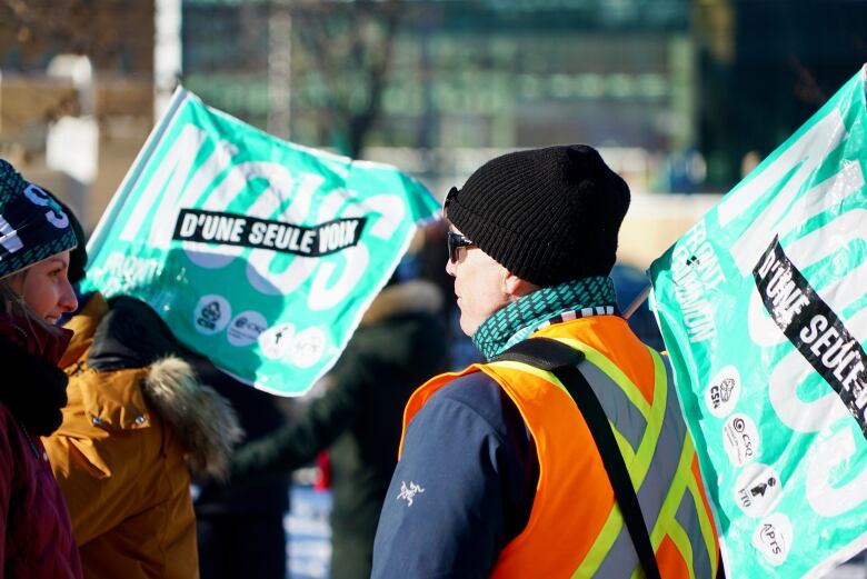 A woman striking in a safety vest.