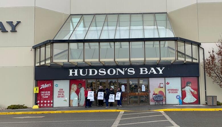 Picketing workers outside a Hudson's Bay store in cold weather.