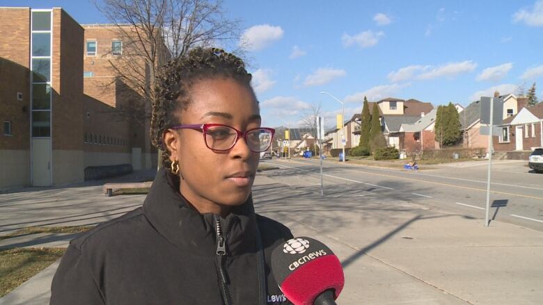 A woman speaking into a CBC microphone.