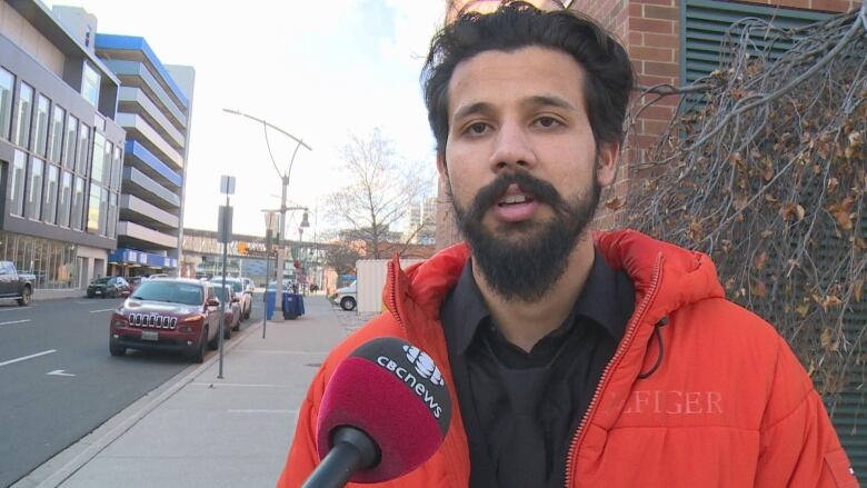 A man speaking into a CBC microphone.